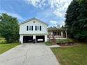 Charming two-story home featuring a front porch, two-car garage, and cars parked inside at 23 Jennifer Ln, Rydal, GA 30171