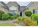 Inviting home featuring manicured shrubs, a walkway leading to the front door and brick exterior at 3865 Portico Run Dr, Buford, GA 30519
