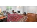 Cozy living room with a gray sofa, fireplace, built-in shelving, and a patterned red rug on hardwood floors at 52 Chaumont Nw Sq, Atlanta, GA 30327