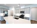 Well-lit kitchen featuring gray cabinets, a pantry, stainless steel appliances, and a quartz countertop island at 621 Pineberry Ct, Grayson, GA 30017
