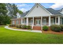 Stately brick home features a covered front porch with columns and professionally landscaped front yard at 1253 Oakwood Pl, Loganville, GA 30052