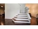 Elegant staircase with hardwood steps and white risers, complemented by rich hardwood floors and bright white walls at 13030 Crabapple Lake Dr, Roswell, GA 30076