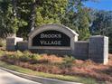 Stone community sign for Brooks Village with manicured landscaping and mature trees at 1473 Autumn Wind Dr, Dacula, GA 30019