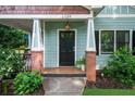 Charming front porch with brick columns and a decorative front door, enhanced by lush landscaping at 2324 Oakview Ne Rd, Atlanta, GA 30317