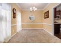 Bright dining room with neutral walls, carpet, and a glimpse of the kitchen at 2451 Broad River Pl, Ellenwood, GA 30294
