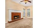 Cozy living room featuring a brick fireplace, plush carpet, and natural light from two windows at 2451 Broad River Pl, Ellenwood, GA 30294