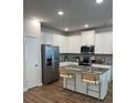 Modern kitchen boasts white cabinets, stainless steel appliances, and a granite island with seating at 4263 Notting Hill Sw Dr, Atlanta, GA 30331