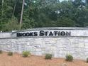 Stone sign at Brooks Station with manicured landscaping and established trees at 1949 Van Allen Ct, Dacula, GA 30019