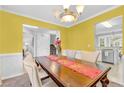 Bright dining room features yellow walls, a large wooden table and chairs, and access to other rooms at 3358 North Ct, Ellenwood, GA 30294