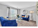 Bright living room featuring a cozy blue sofa set and large windows with sheer curtains at 3358 North Ct, Ellenwood, GA 30294