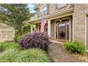 Inviting front porch showcasing lush landscaping and an American flag at 1839 Tranquil Field Nw Dr, Acworth, GA 30102