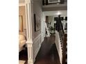 Elegant hallway featuring dark hardwood floors, wainscoting, and a staircase leading to the upper level at 2709 Ratby Ne Ln, Conyers, GA 30013
