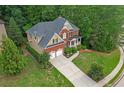 Birds-eye view of a red brick house featuring a two-car garage and mature landscaping at 3310 Vista Creek Dr, Dacula, GA 30019