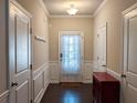 Bright foyer with neutral walls, wainscoting, and dark hardwood floors, complemented by modern lighting at 2508 Norwood Park Xing, Atlanta, GA 30340