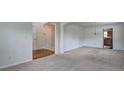Open-concept living area with neutral carpet, decorative wainscoting, and an arched doorway leading to the kitchen at 347 Cobblestone Court, Hampton, GA 30228