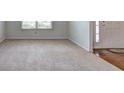 Welcoming living space with wood floors, neutral carpet, a large window, and a bright front door at 347 Cobblestone Court, Hampton, GA 30228