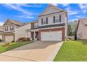 View of a two-story home featuring a well-kept lawn, an attached garage, and manicured landscaping at 911 Sonoma Dr, Lawrenceville, GA 30045