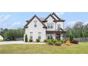 Stunning two-story home with a manicured lawn, professional landscaping, and a paved drive way at 1660 Chandler Rd, Lawrenceville, GA 30045