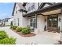 Charming covered front porch with brick columns, double front doors with wreaths, and rocking chairs at 1660 Chandler Rd, Lawrenceville, GA 30045