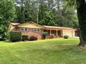 Traditional brick home featuring a well-manicured lawn and mature trees at 3190 Cheru Ct, Decatur, GA 30034