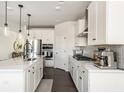 Modern kitchen with white cabinets, stainless steel appliances, an island and stylish pendant lighting at 5025 Bryce Ln, Cumming, GA 30040