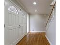 Inviting foyer with hardwood floors, a staircase, and decorative glass on the entry closet at 6010 Spalding Dr, Atlanta, GA 30350