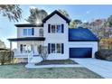 Charming two-story home with white brick, black shutters, an attached garage and a landscaped front yard at 1285 Cedar Brook Dr, Lawrenceville, GA 30043