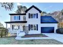 Charming two-story home with white brick, black shutters, an attached garage and a landscaped front yard at 1285 Cedar Brook Dr, Lawrenceville, GA 30043