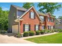 Side view of a red brick home with a two-car garage and mature landscaping at 100 Chadwick Pl, Villa Rica, GA 30180