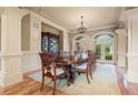 Formal dining room with a large table, elegant chandelier, and arched windows overlooking the backyard at 179 Worthington Way, Jonesboro, GA 30236
