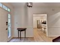 Inviting entryway with light wood flooring, a classic table, and views into the adjacent kitchen at 248 Riverview Trl, Roswell, GA 30075