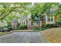 Charming townhome featuring a brick facade, manicured landscaping, and a welcoming entrance framed by lush greenery at 248 Riverview Trl, Roswell, GA 30075