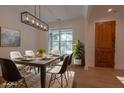 Bright dining room with modern light fixture, hardwood floors, and a large window showcasing the yard at 3007 Holly St, Canton, GA 30115