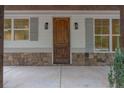 Inviting entryway featuring a solid wood front door, stone accents, and stylish exterior lighting at 3007 Holly St, Canton, GA 30115