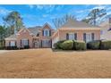Charming brick home featuring manicured landscaping and a well-maintained front lawn at 2021 Cockrell Pointe Nw, Kennesaw, GA 30152