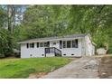 Attractive one-story white home with black shutters, front yard, and long driveway at 2765 Ocean Valley Dr, Atlanta, GA 30349