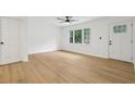 Bright living room features white walls, wood-look floors, a ceiling fan, and a view to the front yard at 2765 Ocean Valley Dr, Atlanta, GA 30349
