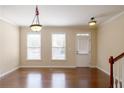 Bright living room features hardwood floors, two light fixtures and a back door at 4400 Village Field Pl, Suwanee, GA 30024
