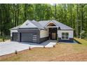 Charming home showcasing a black brick facade, modern garage doors and a well-manicured lawn at 632 Hunters Cove Ln., Loganville, GA 30052