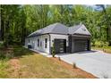 Angle view of the home showing the modern garage doors, brick and siding exterior, and landscaping at 632 Hunters Cove Ln., Loganville, GA 30052