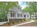 Attractive house with blue shutters and a well-maintained yard and sidewalk in a wooded area at 7533 Mason Falls Dr, Winston, GA 30187