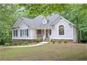 Quaint single-story home with blue shutters, tidy landscaping, and a peaceful wooded setting at 7533 Mason Falls Dr, Winston, GA 30187