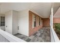 Inviting front porch featuring stone flooring, a white railing, and brick siding at 105 Hunters, Mcdonough, GA 30253