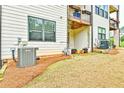 Backyard featuring an A/C unit, mulch bed, and view of a balcony on the back of the house at 1122 Provence Ln, Decatur, GA 30033