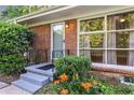 Covered front porch with black railing and a garden featuring colorful flowers at 1461 Alverado Way, Decatur, GA 30032