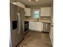 Modern kitchen featuring stainless steel appliances, white cabinets, and sleek countertops at 1461 Alverado Way, Decatur, GA 30032