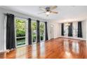 Spacious living room with hardwood floors, a ceiling fan, and large windows overlooking a green yard at 1461 Alverado Way, Decatur, GA 30032