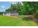 Grassy side yard featuring a wooden fence, and access gate for outdoor activities at 1810 King Mill Rd, Mcdonough, GA 30252