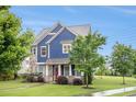 Two-story home with blue siding and stone accents, surrounded by mature trees and a green lawn at 1946 Jeffery Nw Rd, Atlanta, GA 30318
