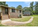 Close-up view of the brick facade and tidy landscaping of this well-maintained home at 530 Village Green Sw Ct, Lilburn, GA 30047